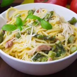 Pyszna carbonara ze szparagami, udekorowana bazylią i parmezanem, gotowa do podania.